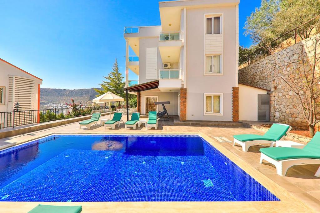 una piscina con sedie e una casa di Villa Mevsim a Kaş