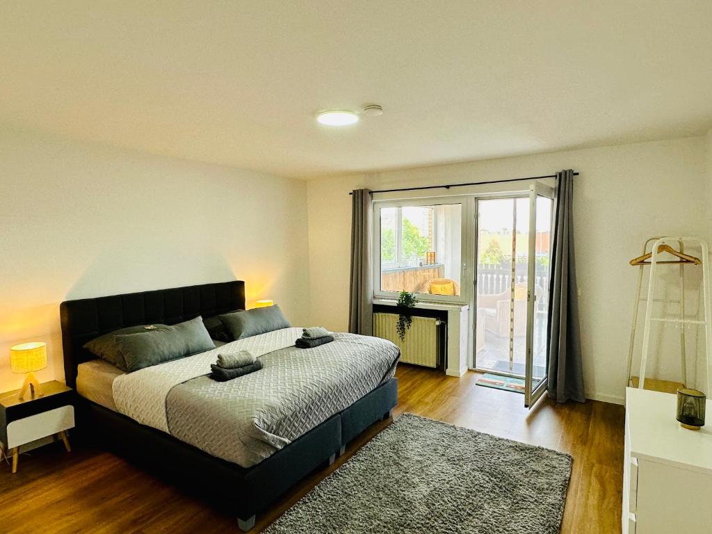 a bedroom with a bed and a large window at Traumhafte 115 qm Ferienwohnung am Steinhuder Meer, Ruhig, Komfortabel, Loggia, Parkplatz, WiFi in Wunstorf