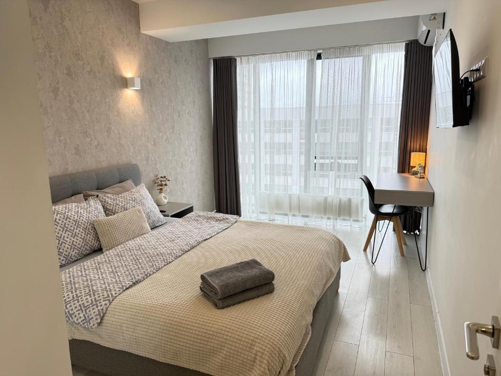 1 dormitorio con cama y escritorio junto a una ventana en RentNow Ultracentral Modern Apartment, en Chişinău