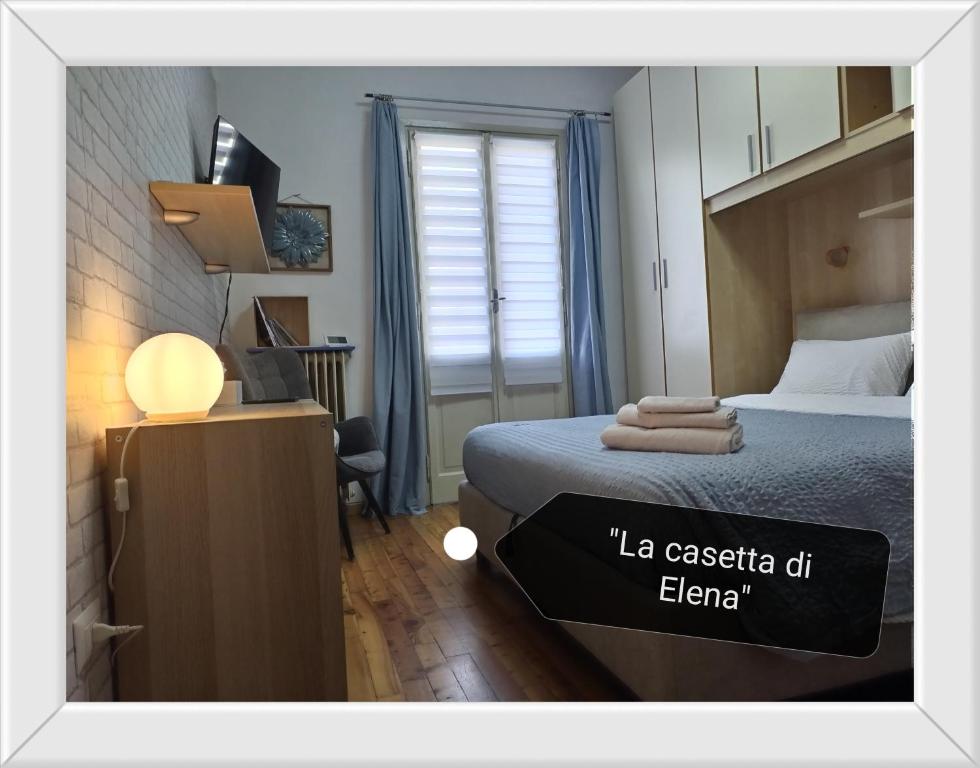 a bedroom with a bed and a desk with a lamp at Valtellina-La casetta di Elena in Sondrio