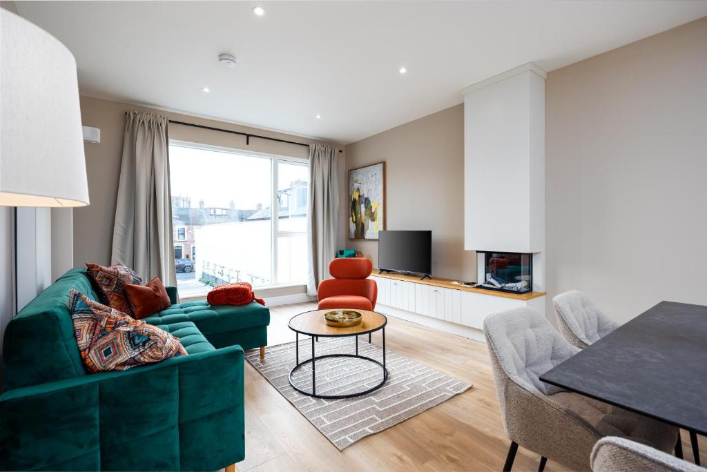 a living room with a green couch and chairs at New 2-Bed Home with Garden Near Google Dublin HQ & Train Station in Dublin