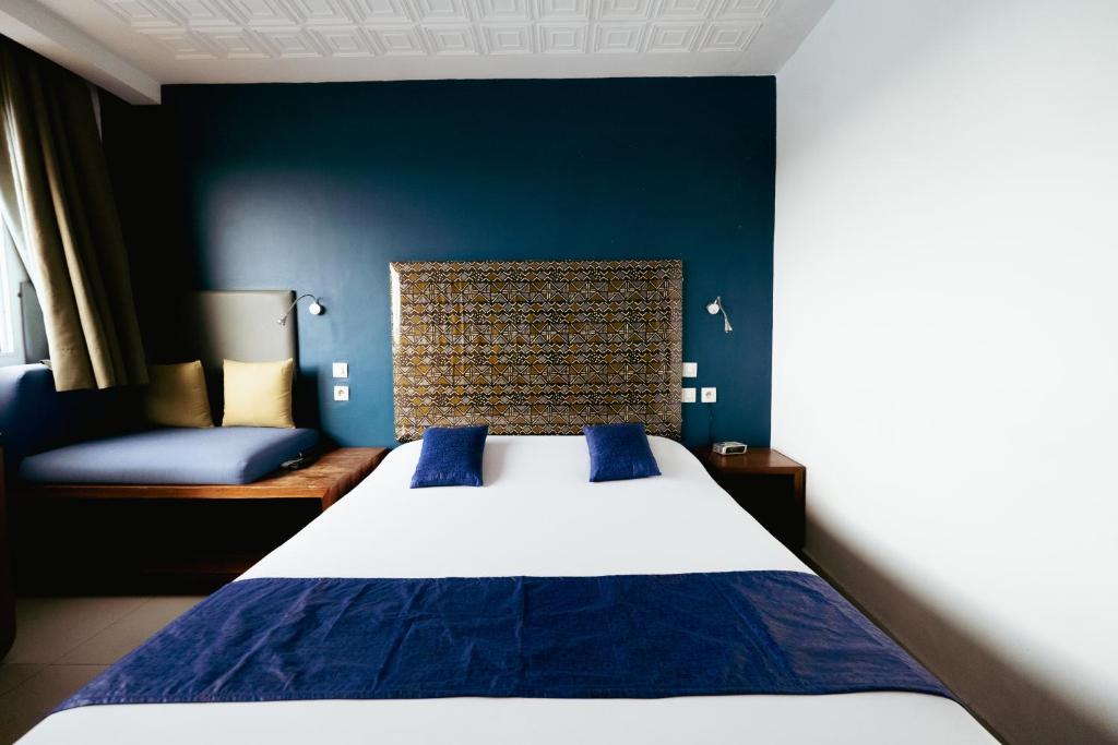 a bedroom with a large bed and a blue wall at Résidence Bertille Abidjan Cocody in Abidjan