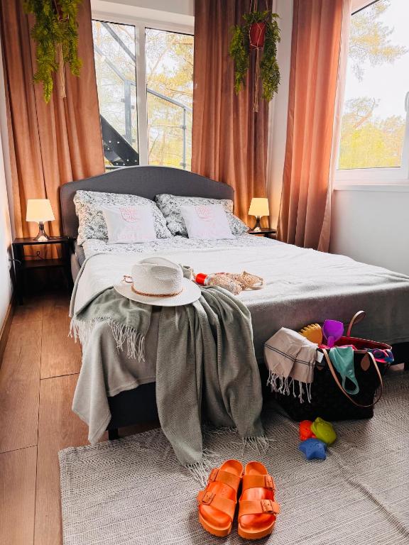 a bedroom with a bed and a table with shoes at Poddąbek Comfort I Apartamenty z tarasem na dachu, ogródkiem, basenem zewnętrznym i wewnętrznym, salą zabaw i animacjami in Poddąbie