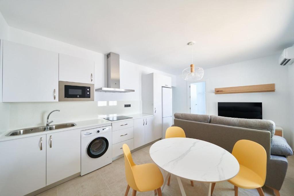 een keuken en een woonkamer met een tafel en stoelen bij Eryan II in San José