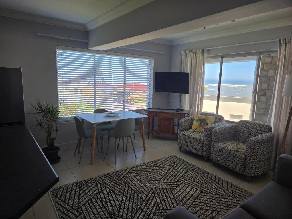 sala de estar con mesa, sofá y comedor en Coastal Bliss Steps from Beach, en Cape Town