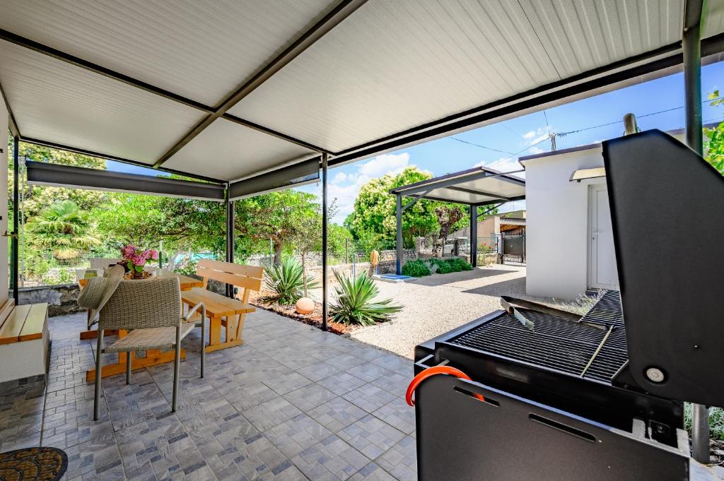 an outdoor patio with a grill and a table and chairs at Kuća za odmor Miha in Tar