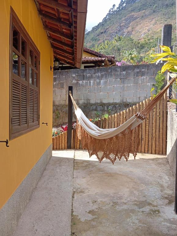 a hammock hanging outside of a house at Chalé da Lili in Nova Friburgo