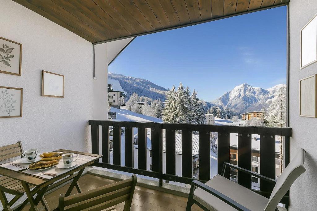 a balcony with a table and chairs and a large window at Il Balcone Sulle Alpi ski in ski out - Happy Rentals in Sauze d'Oulx