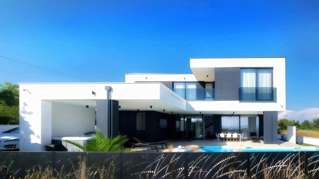 a large white house with a swimming pool at Villa 1 in Kožino