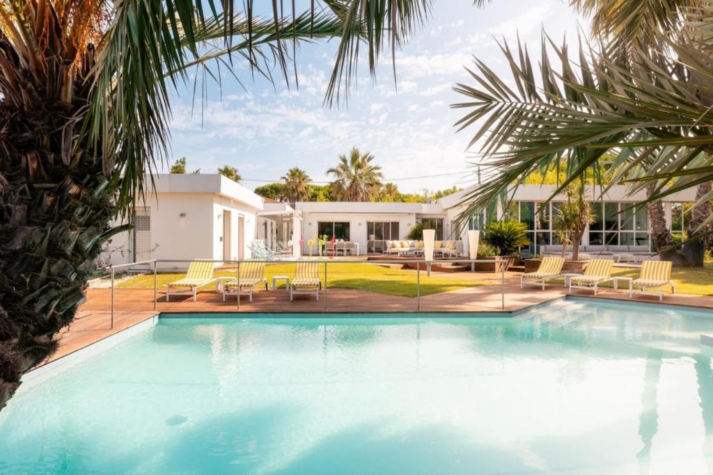 a swimming pool in front of a house at Villa Summer Wind - Palm Beach Agathois in Le Grau-dʼAgde