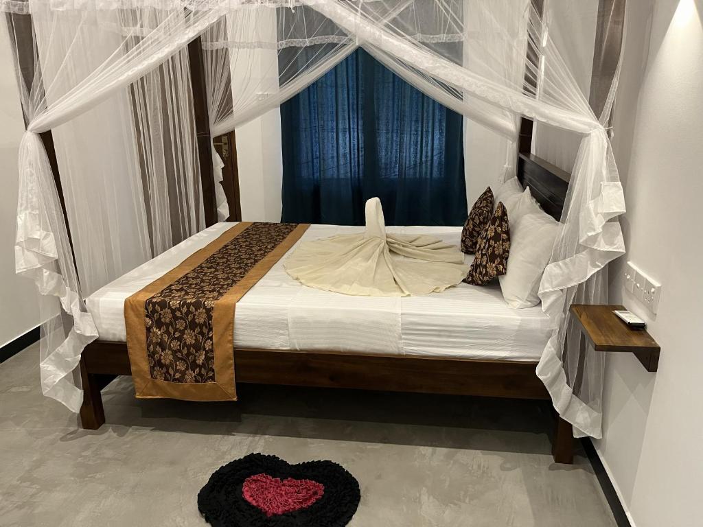 a bedroom with a bed with a canopy at Green Wall House in Dickwella