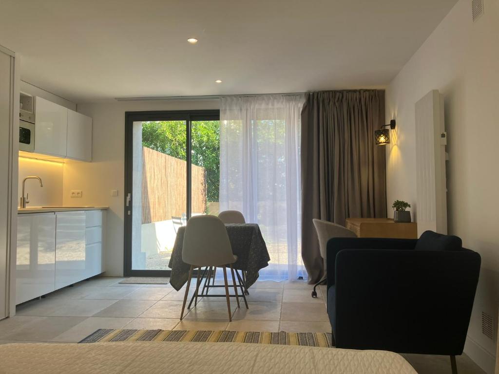 Una cocina y una sala de estar con mesa y sillas. en Studio neuf dans un écrin de verdure, en Charbonnières-les-Bains