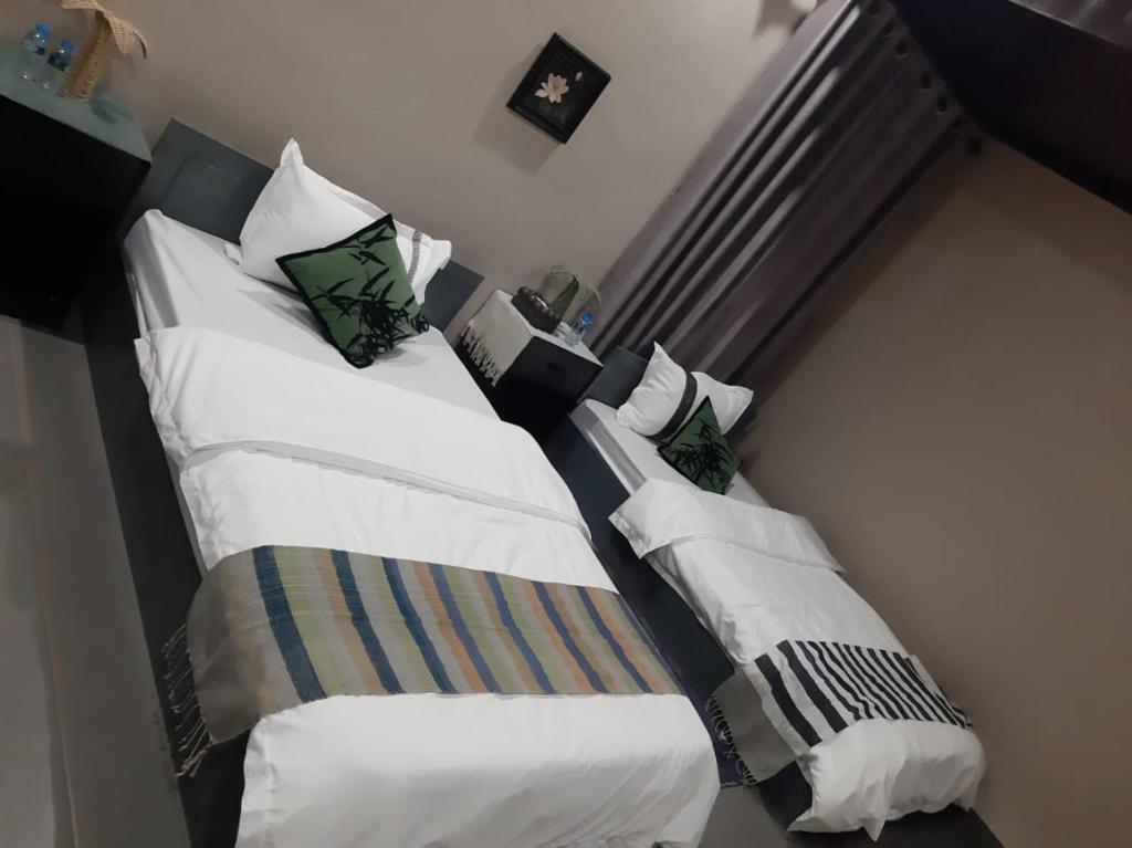 NongkhiawVinla Guesthouse & Backpackers Hostel的卧室内的两张床,配有白色床单和枕头