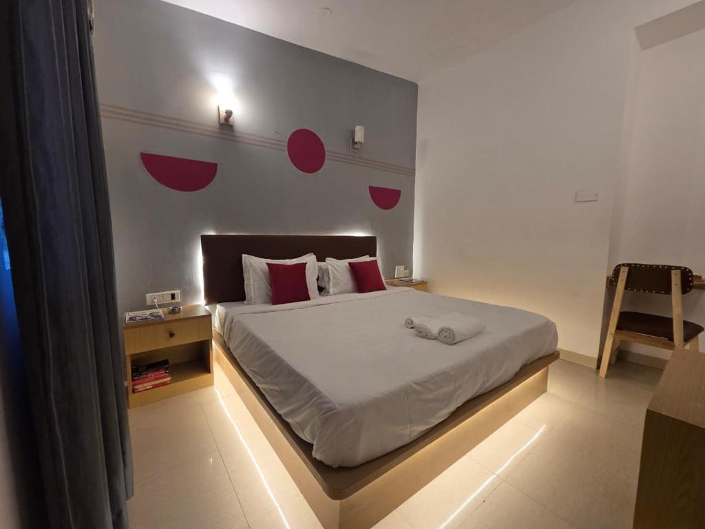 a bedroom with a bed with red dots on the wall at Baga Waves by Dia Hotels And Homes in Calangute
