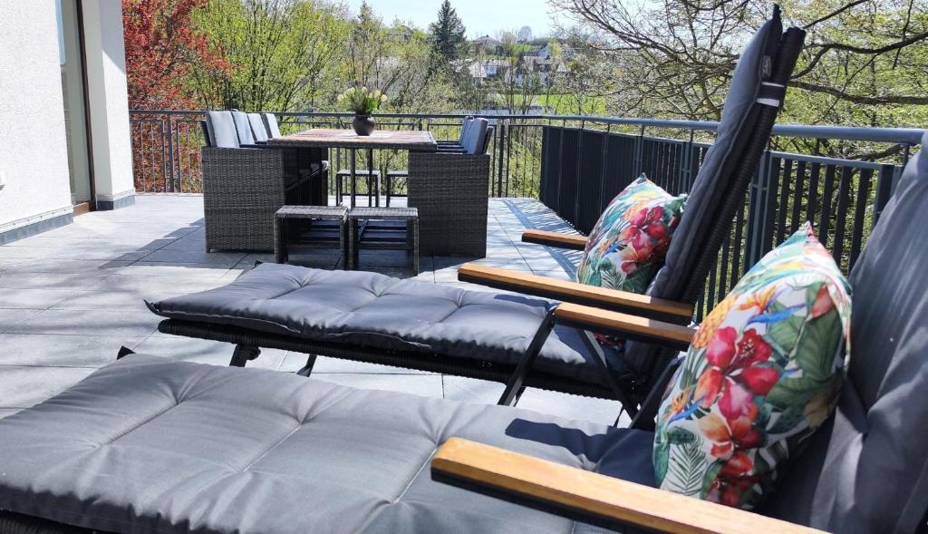 a patio with two chairs and a table on a balcony at Chalet am Diemelsee mit Seeblick im Sauerland in Heringhausen