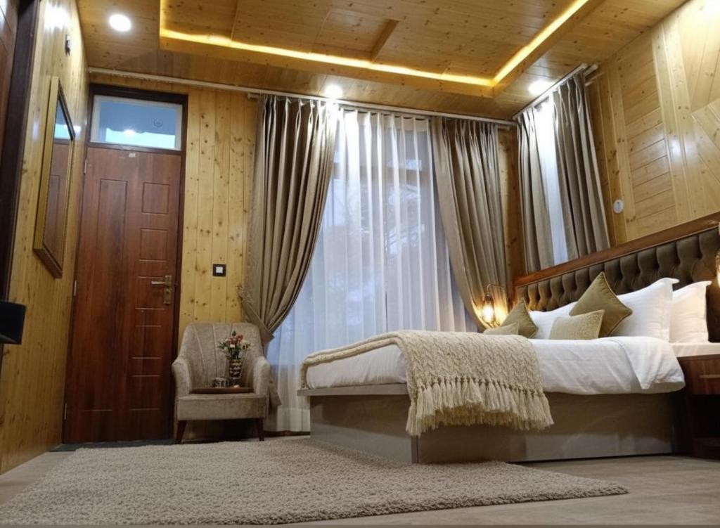 a bedroom with a large bed and a window at Chatnya Homes Kasauli by Splendid Hotels - Family Groups Events in Kasauli