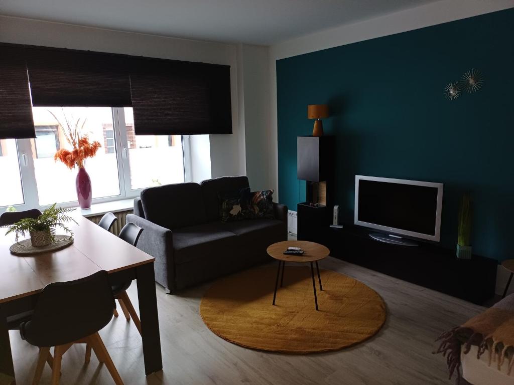 een woonkamer met een bank en een tv bij Henry in Schiffweiler