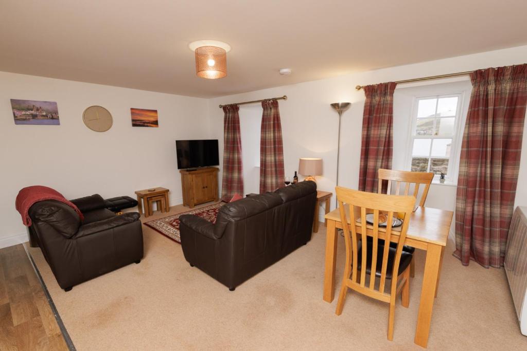 a living room with a couch and a table at Auld Haa Apartments, Shetland Islands in Scalloway