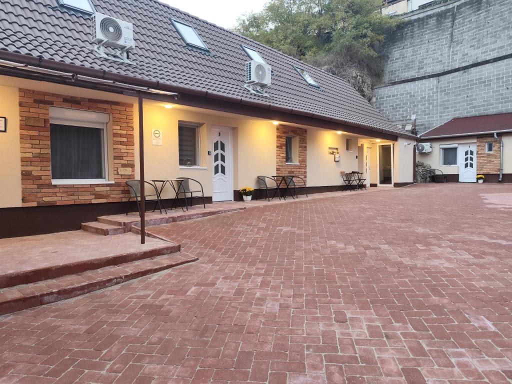a building with a brick courtyard with tables and chairs at Némó Apartman in Eger