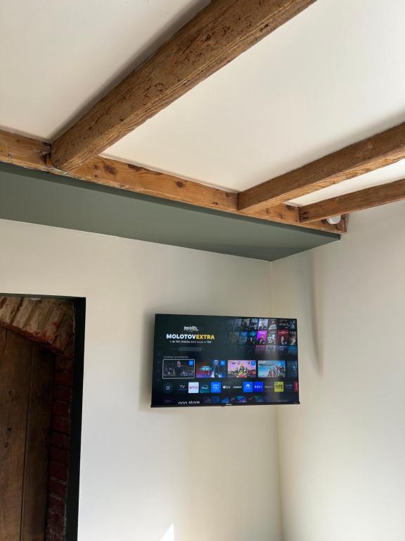 a flat screen tv hanging from a ceiling at Le Cocon Secret in Saint-Cyr