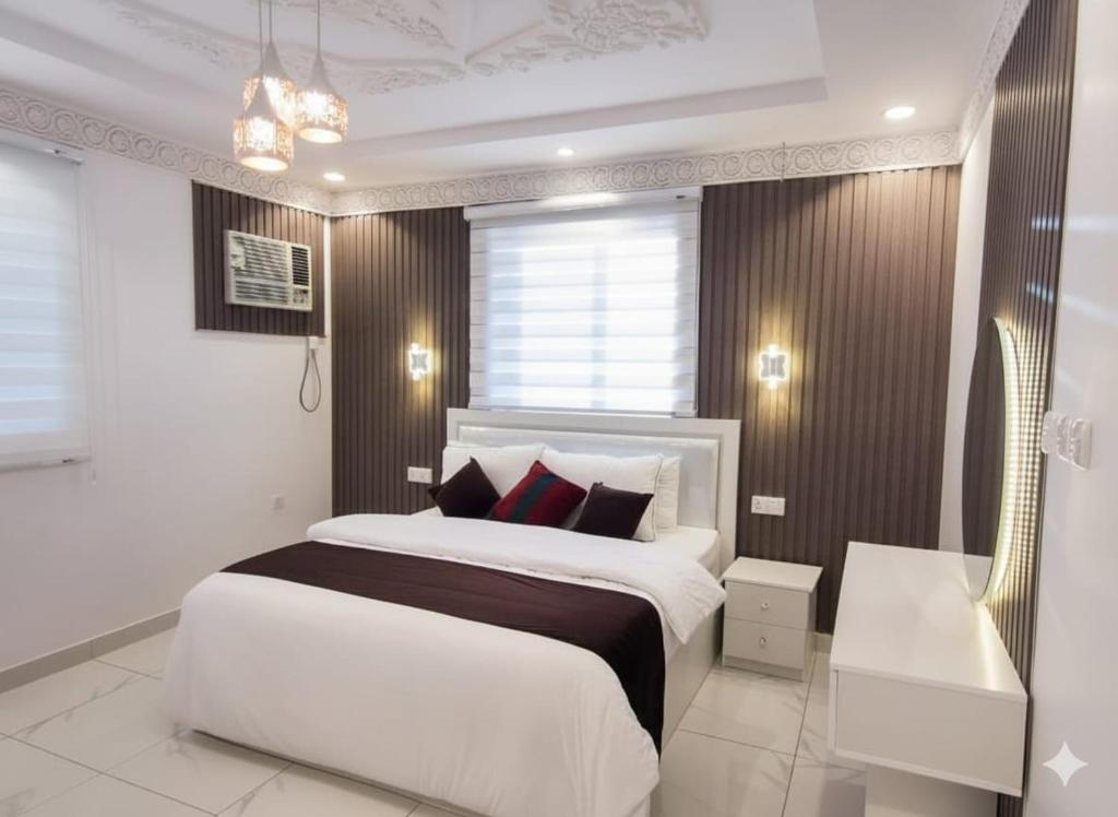 a bedroom with a large white bed with red pillows at شقق النبلاء in Al Madinah