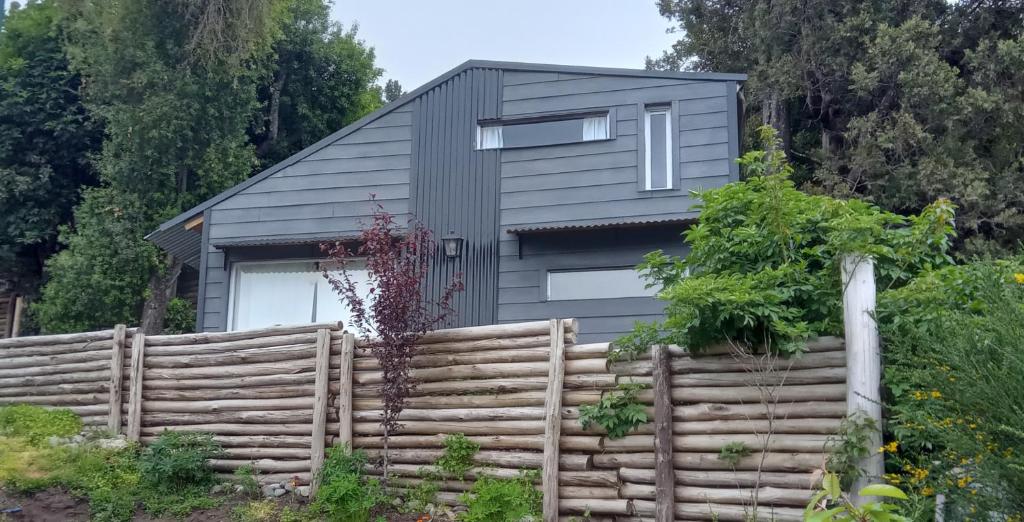 een huis met een hek ervoor bij Tiny House de montaña in San Martín de los Andes