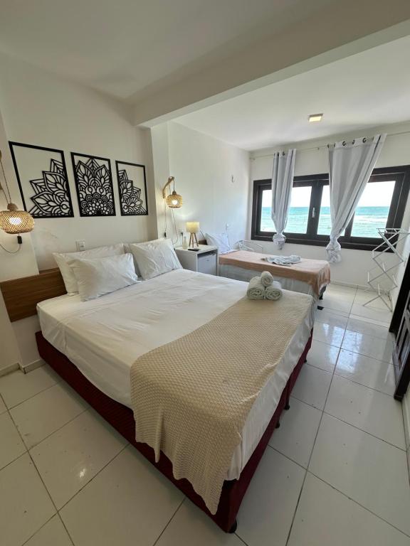 een slaapkamer met een groot bed en een bureau bij Pousada Maramar/terceira praia MSP in Morro de São Paulo