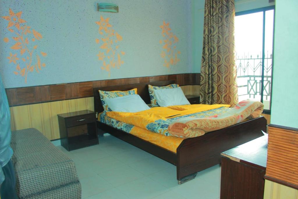 Un dormitorio con una cama y una ventana en Hotel Mount Heaven, en Murree