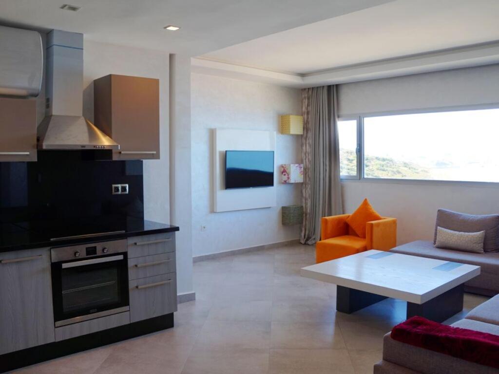 フニデクにあるHotel Honorのソファとテーブルのあるキッチンとリビングルーム