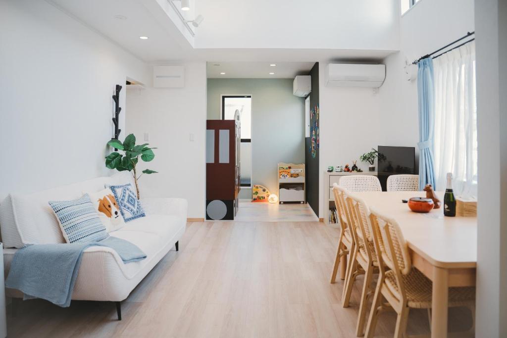 a living room with a white couch and a table at Mulan Stay 松尾大社 in Kyoto