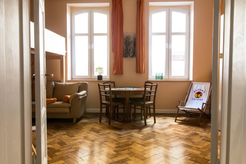 a dining room with a table and chairs and windows at Apartament Hamak in Sopot