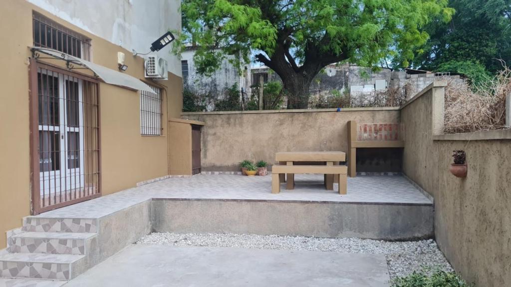 een houten bankje op de binnenplaats van een gebouw bij kairos in La Falda