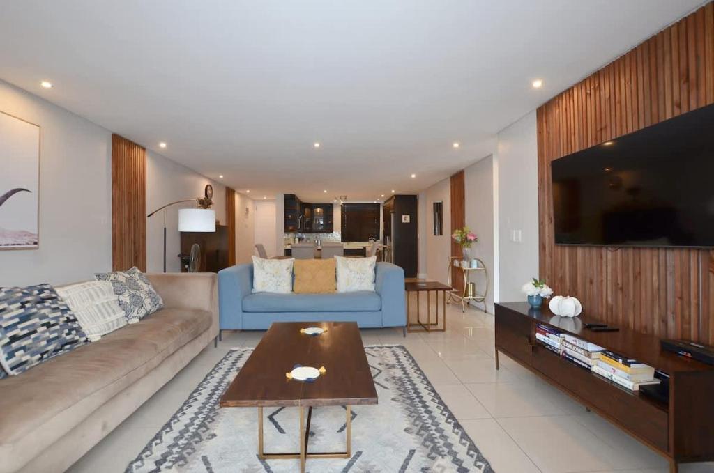 un soggiorno con un divano e un tavolo di Elegant Contemporary Apartment at Eden on the Bay a Big Bay