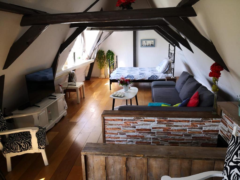 a living room with a couch and a brick fireplace at De WitteZwaan in Harlingen