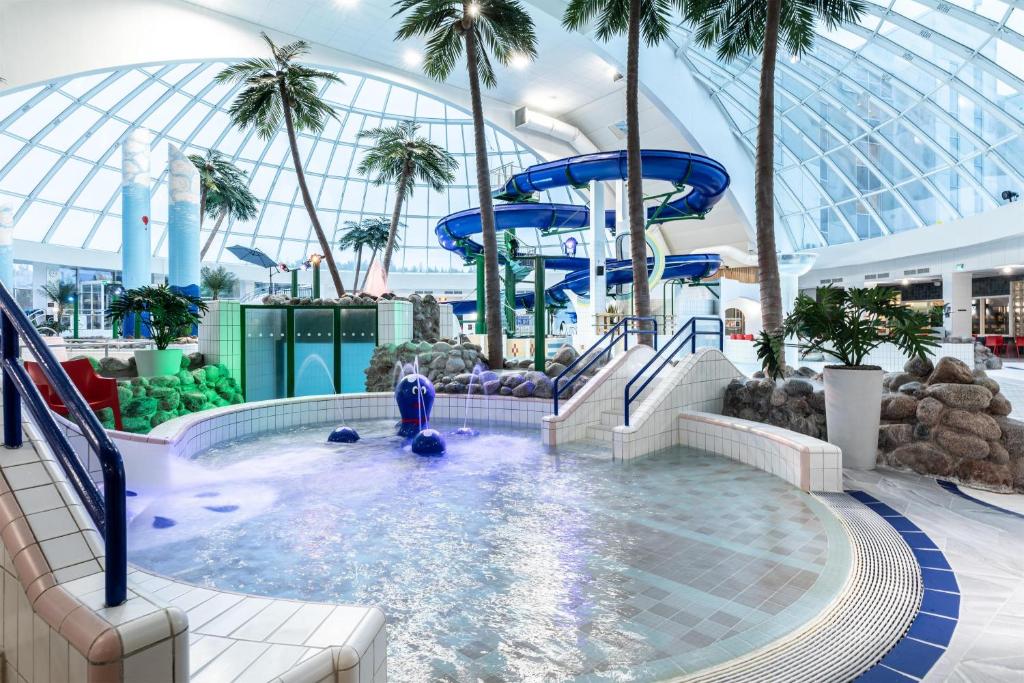 a pool on a cruise ship with palm trees at Scandic Eden Nokia in Nokia