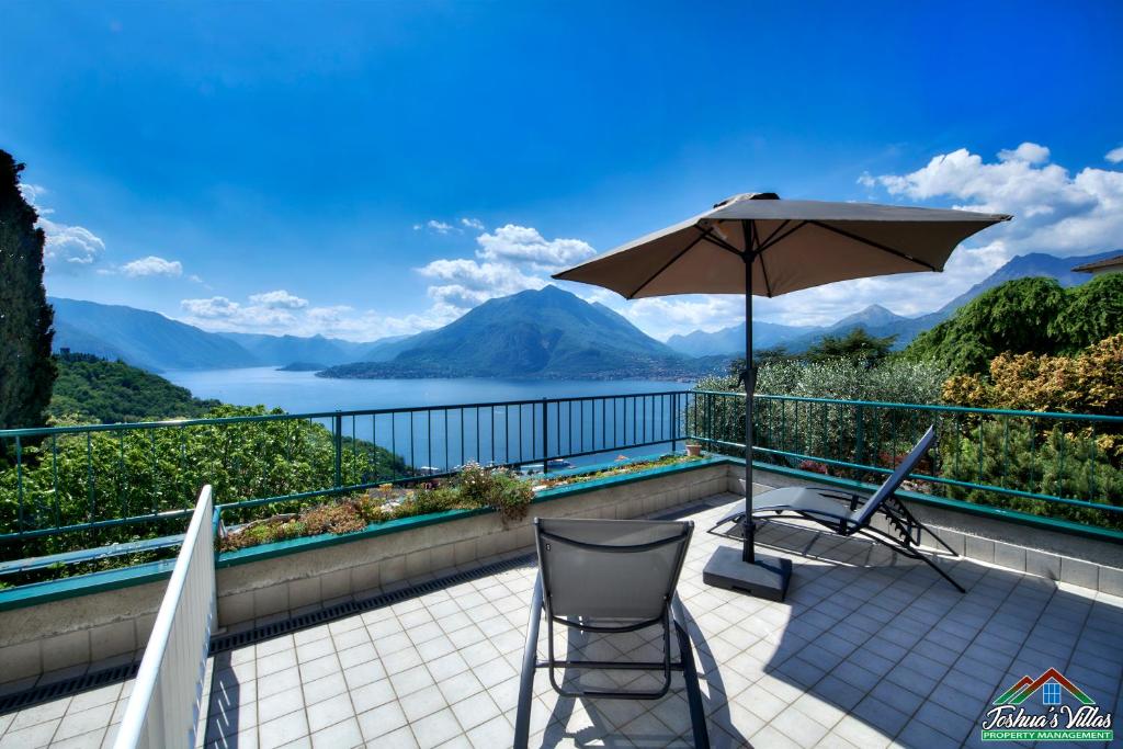 a patio with an umbrella and a chair at Sunset Apartment with Air Conditioning and Lake View in Perledo