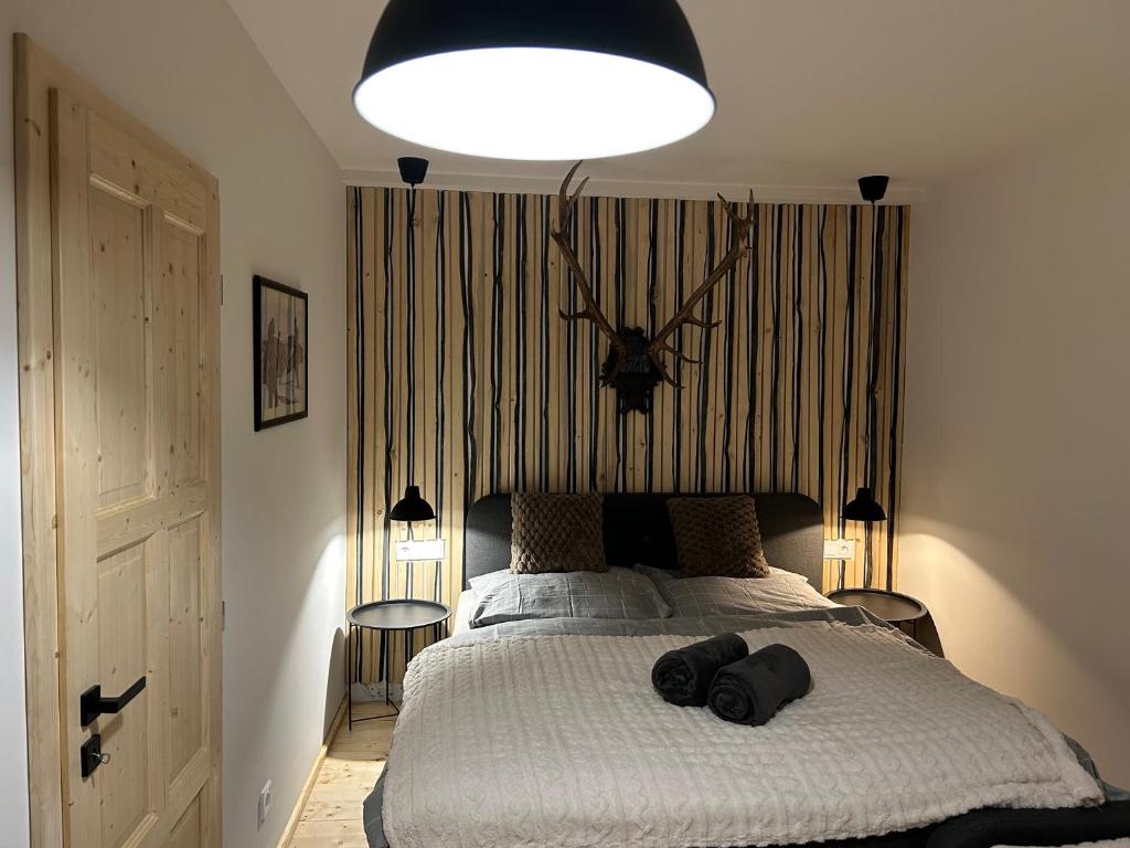 een slaapkamer met een groot bed met een klok aan de muur bij Harrachovský Chalet u sjezdovky 