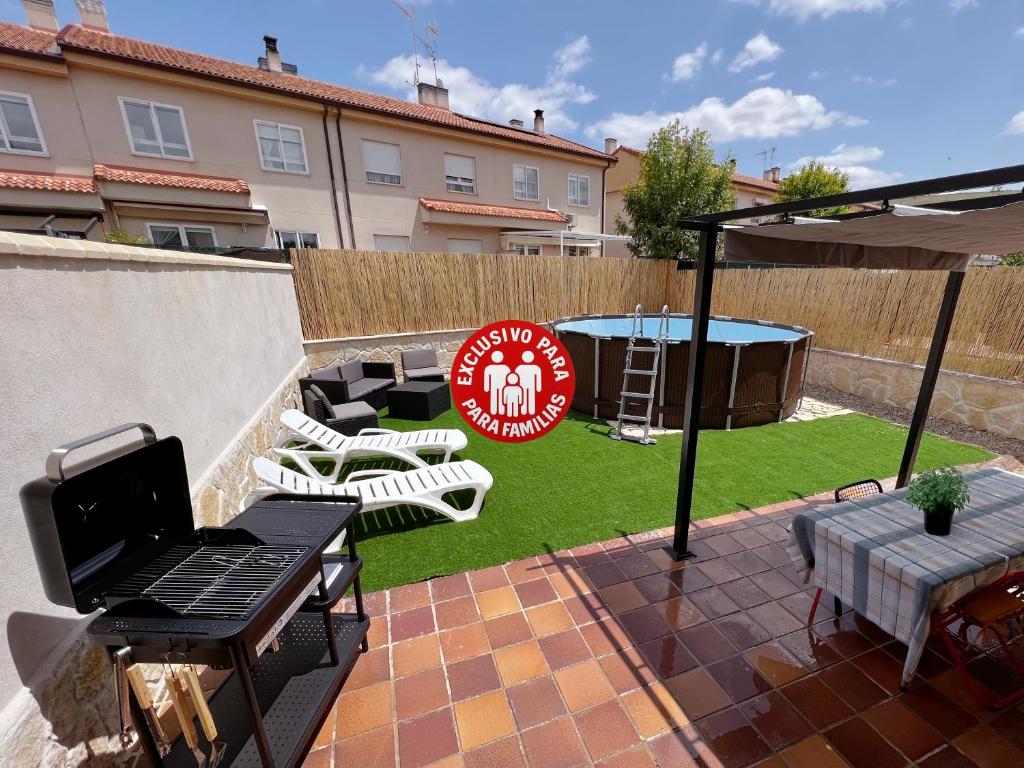 a backyard with a grill and a table and chairs at Chalet a 15 min de Segovia con barbacoa y piscina in Hontanares de Eresma