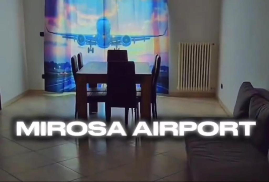 a dining room with a table and chairs and a couch at mirosa airport home in Macchie