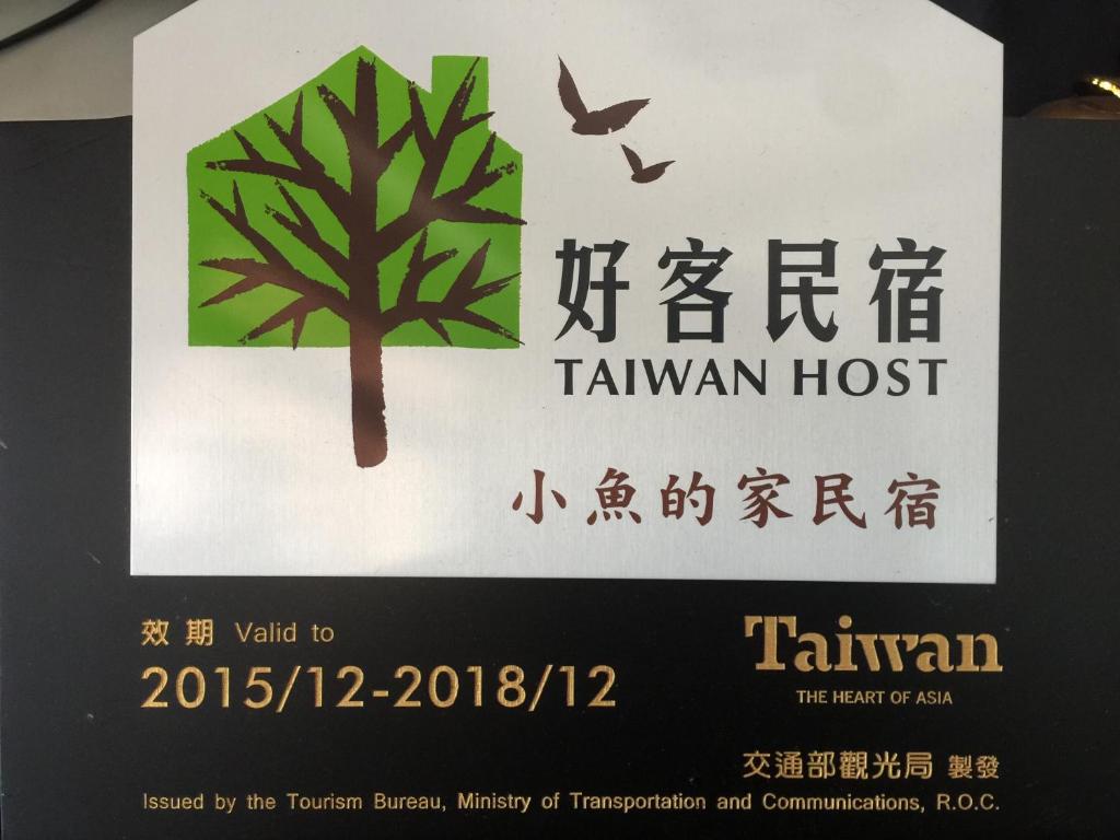 a sign for a taranothan hospital with a tree at Fish House Hostel in Wujie