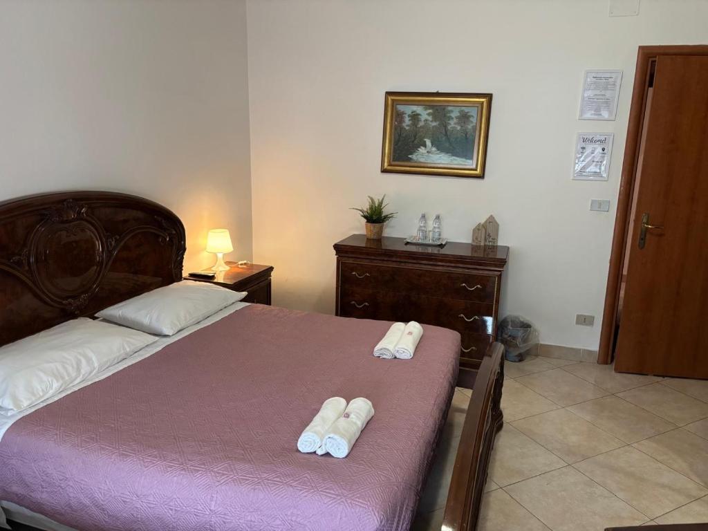 a bedroom with a bed with two slippers on it at B&B Altea in Pescara