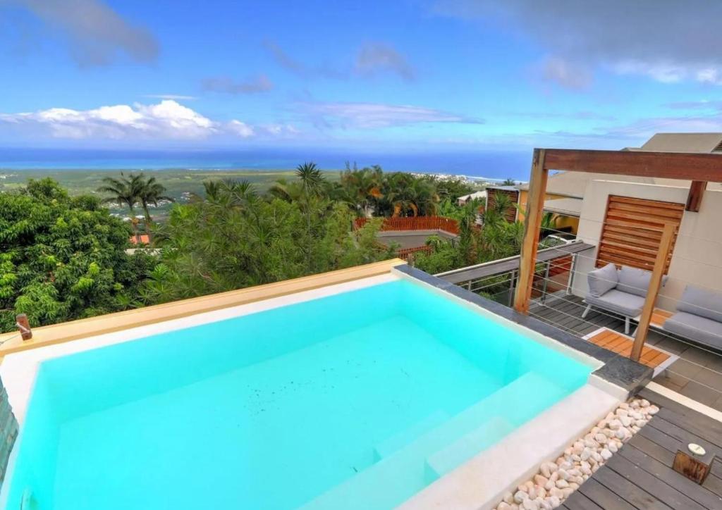 a pool on the roof of a house with a view at Villa Swahili1 in Les Avirons