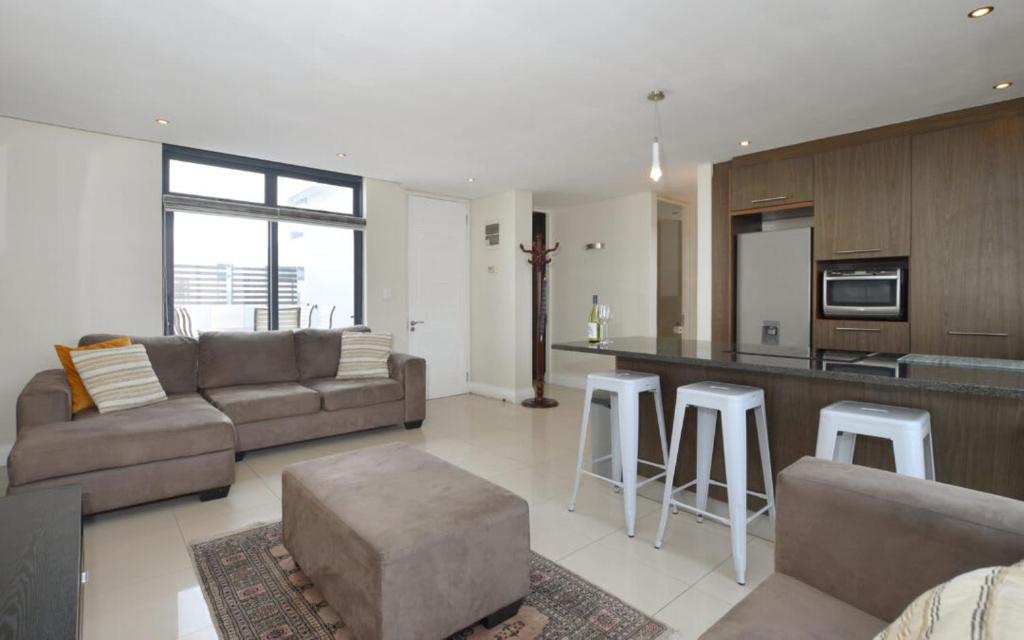 a living room with a couch and a kitchen at Neat Apartment at Eden on the Bay in Big Bay