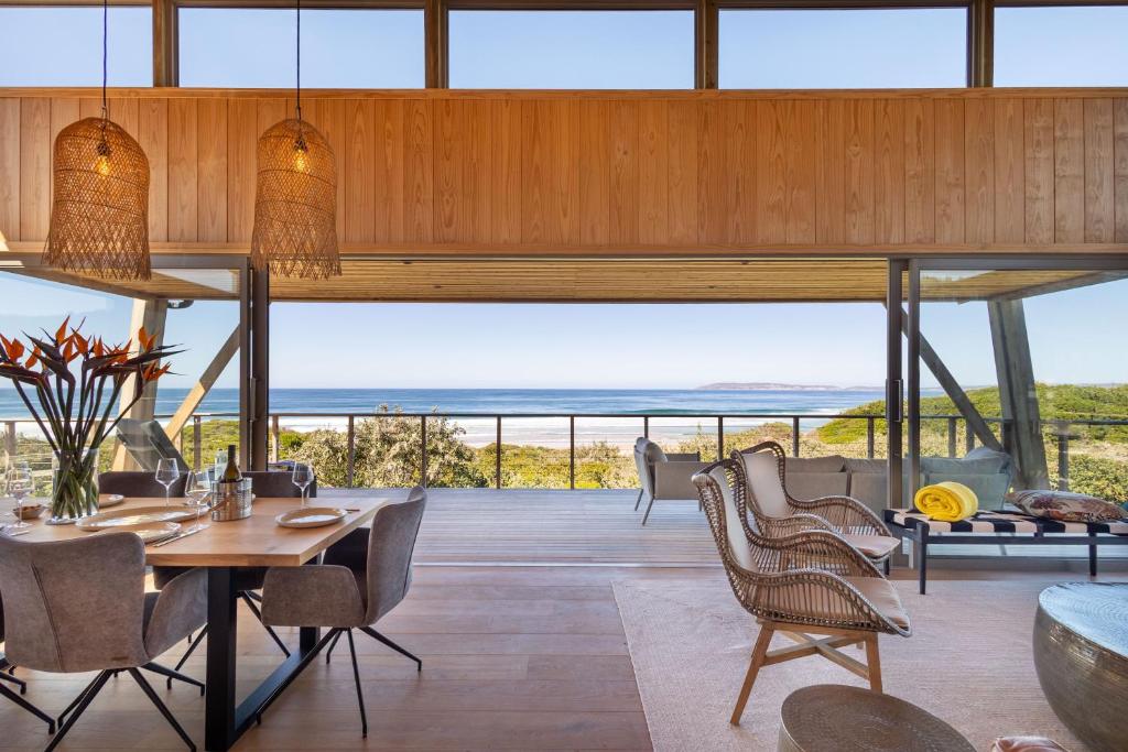 ein Esszimmer mit Blick auf das Meer in der Unterkunft Dune Seaside Cottage in Plettenberg Bay