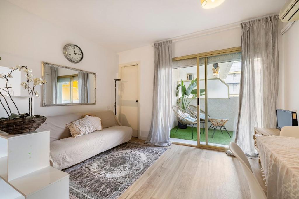 a white living room with a couch and a clock at Pet Friendly + Pool + Park, Beach 2 Minutes Away (Atalaya) in Salou
