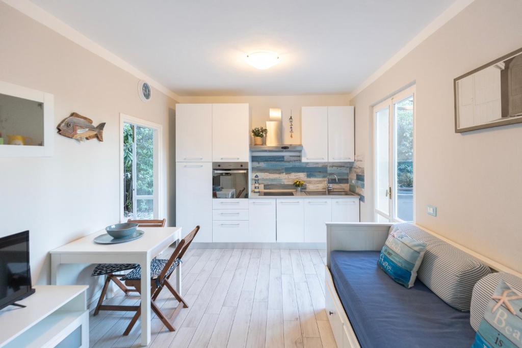 a kitchen and living room with a table and a couch at Appartamento Pino Fetovaia by ElbaSummer Tour Operator in Fetovaia