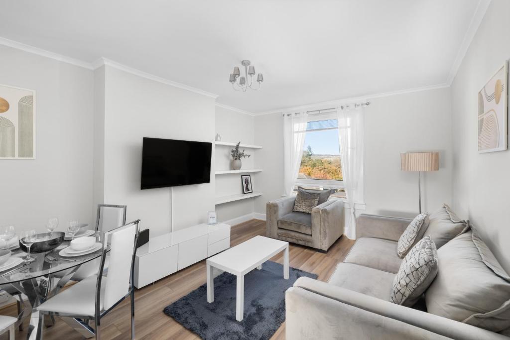 a white living room with a couch and a table at Sidlaw View in Dundee