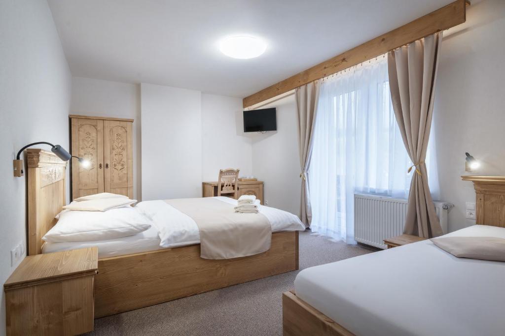 a bedroom with two beds and a window at Penzión u Pavla in Ždiar