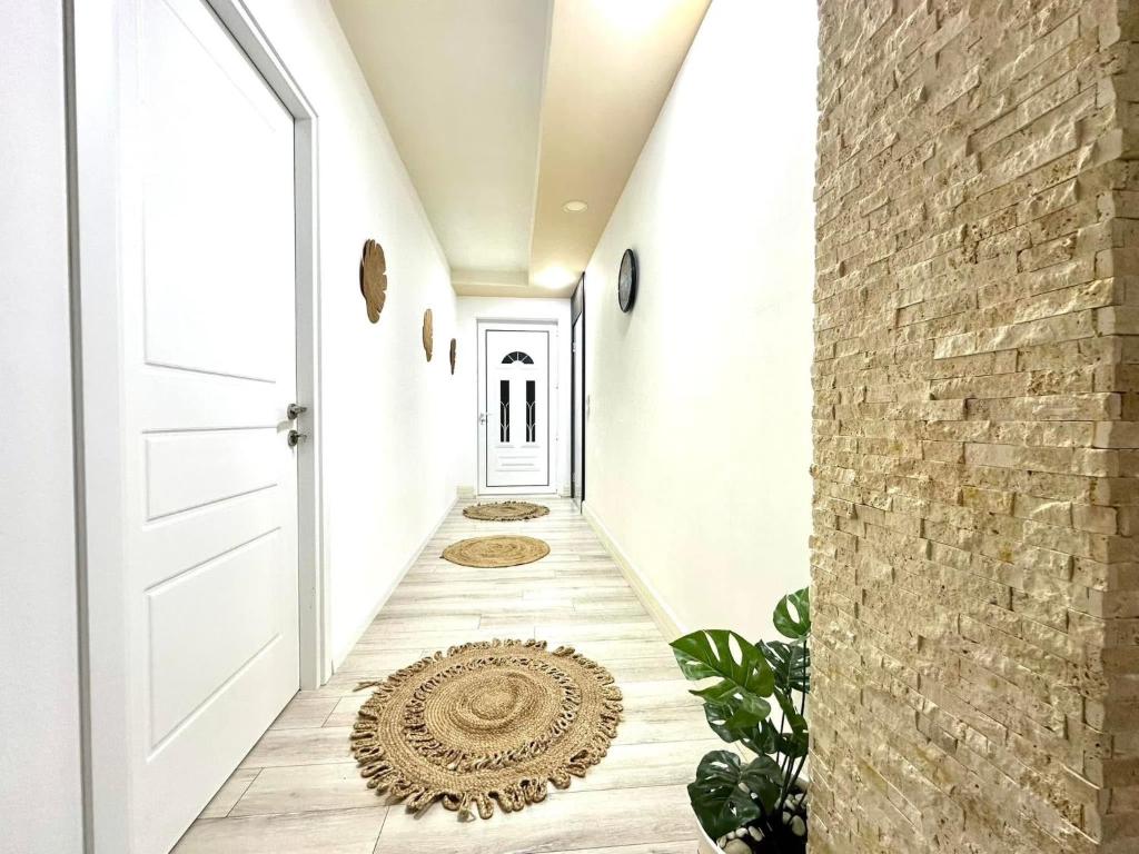 een hal met een witte deur en een bakstenen muur bij LuxuryHomeUlcinj in Ulcinj