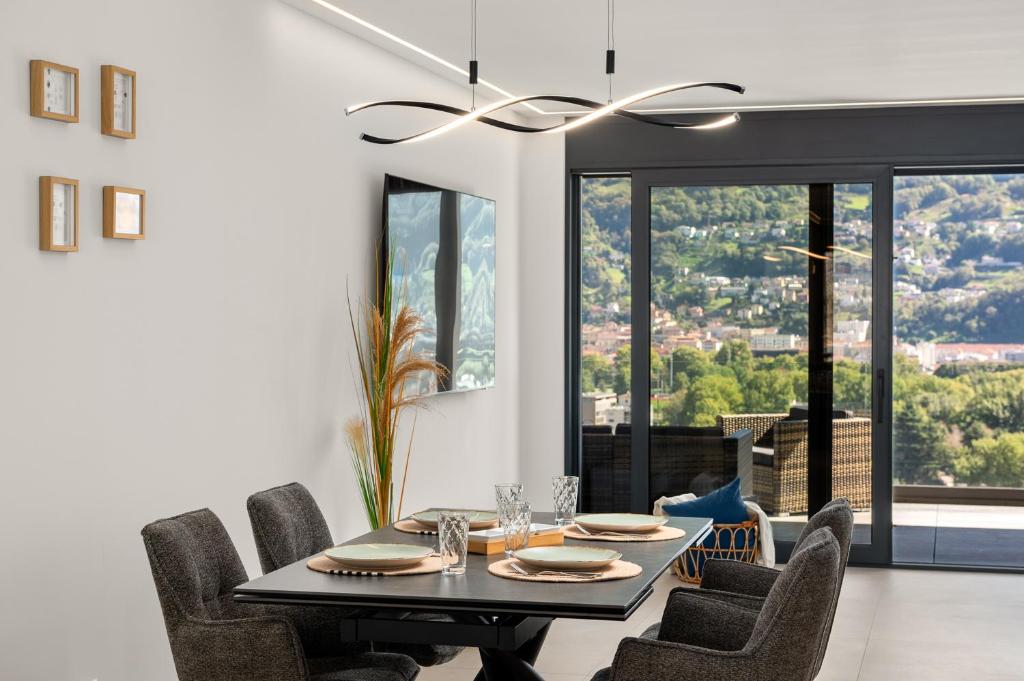 a dining room with a black table and chairs at Panorama Royale Penthouse in Bellinzona